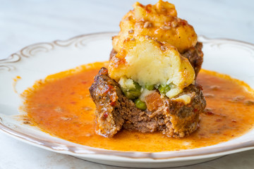 Turkish Food Hasanpasa Kofte / Kofta with Puree / Meatball with Bechamel, Tomato Paste Sauce and Green Peas.
