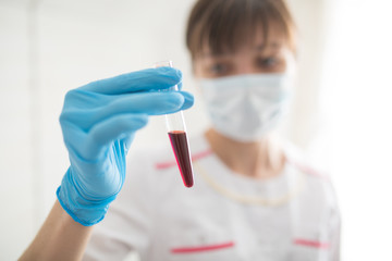 Female nurse holding a test tube with a blood sample