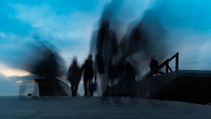 Silhouettes of people on the bridge long exposure photo. city people