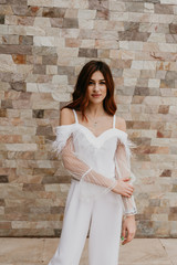 Beautiful lady in black-and-white dress posing near white brick wall. Beauty, fashion concept.