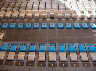 Sound mixer control panel with sliders and buttons closeup. Selective focus.