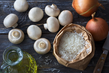 Ingredients for a delicious vegan dish. White basmati rice, garlic and champignons on a wooden table, top view, horizontal