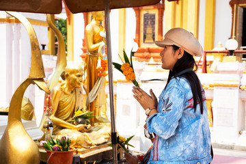 Travelers thai women travel visit and posing portrait and respect praying buddha statue with Pagoda or Stupa at Wat Phra That Renu Nakhon temple in Nakhon Phanom, Thailand