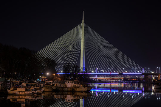 Ada bridge illuminated at night with beautiful water reflection, famous Belgrade landmark