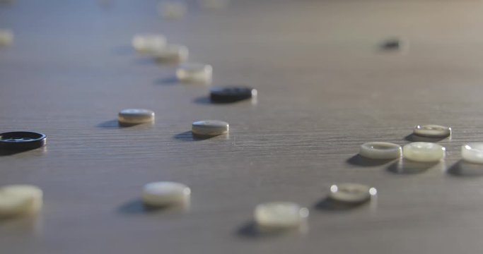 Slow motion of close-up of various colorful buttons on a table. Different colored buttons made of plastic. Sewing supplies, Accessories for clothes, Sewing thread, Sewing buttons,Textile accessory
