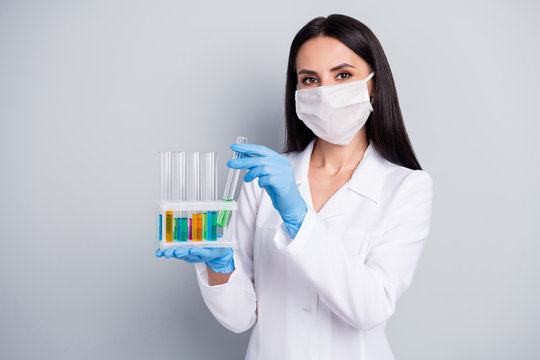 Close-up portrait of her she nice attractive girl biologist scientist expert doc holding in hands flasks analyzing creating remedy cure meds medical solution isolated over grey pastel color background - Powered by Adobe