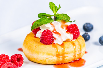 Delicious dessert of donuts. Sweet donuts with different fresh fruit and decorations. Closeup