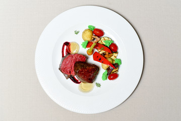 Meat steak with vegetables on a white plate