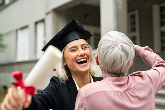 Laughing graduate student embracing mother