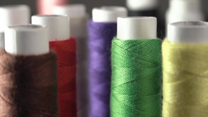 Sewing Threads On Spool. Extreme Closeup. Colorful spools of thread in textile factory. A Lot of...