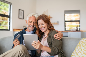 Mature couple doing online shopping with digital tablet