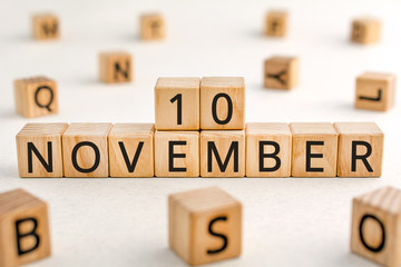 November 10 - from wooden blocks with letters, important date concept, white background random letters around