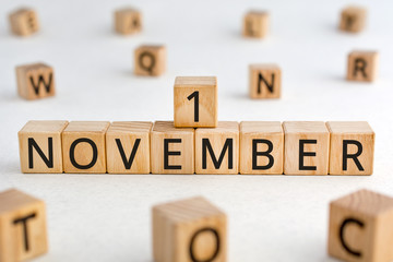 November 1 - from wooden blocks with letters, important date concept, white background random letters around