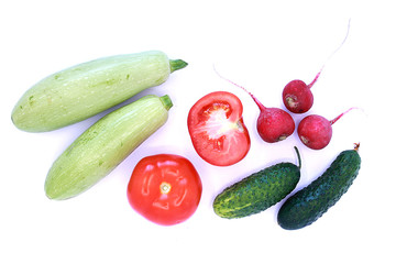 Tomatoes, cucumbers, radishes and zucchini on a white background, close-up