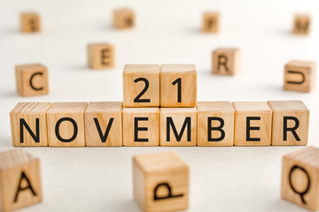 November 21 - from wooden blocks with letters, important date concept, white background random letters around