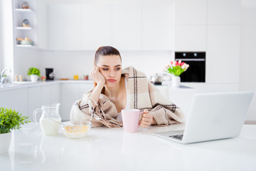 Photo of sleepy housewife lady covered blanket morning lazy worker have breakfast drink coffee look notebook table not interested stay home quarantine time remote worker indoors