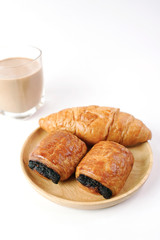 Close up Chocolate and butter croissant with glass of milk tea on white background                                                                                                  