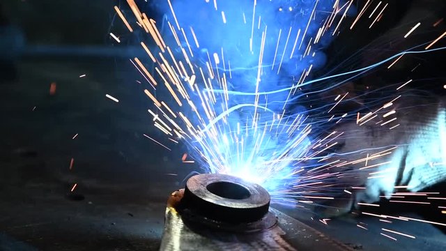 Welder worker at industrial arc welding work
