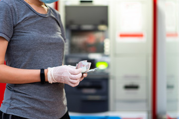 Woman counting money wearing protective gloves
