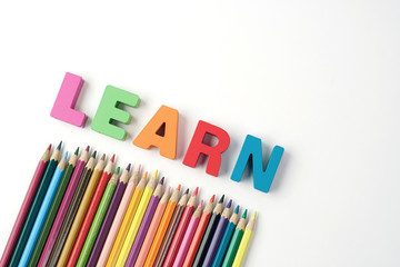 Colorful Wooden Letters ' LEARN ' with Color Pencil on White Background                                                            