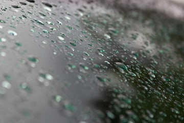 Background of raindrops on car glass at dusk