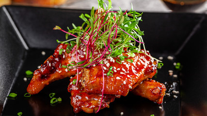 American cuisine. Juicy fried chicken wings glazed with sesame seeds and herbs. Beautiful serving...