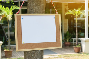 white paper post blank text message note on notice board advertisement hanging under tree
