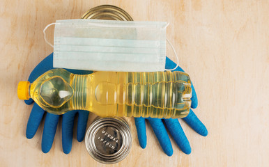 Blue medical gloves and medical mask with food donation products.