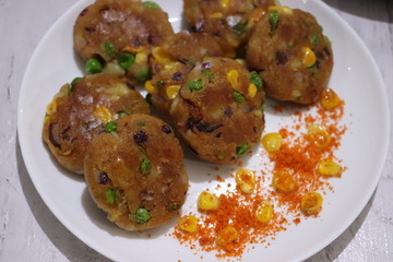 Crunchy bread cultlets, vegetables, corn and peas