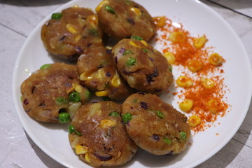 Crunchy bread cultlets, vegetables, corn and peas