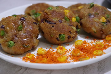 Crunchy bread cultlets, vegetables, corn and peas