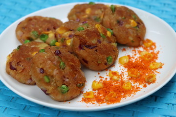 Crunchy bread cultlets, vegetables, corn and peas
