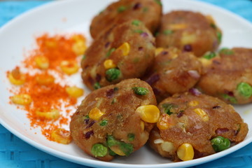 Crunchy bread cultlets, vegetables, corn and peas