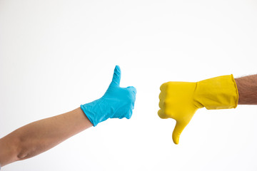 Caucasian woman and man hand in blue and yellow latex gloves doing the thumb up and down signs isolate on white