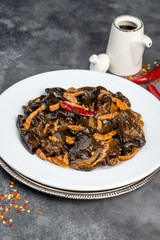 Wood mushrooms with meat in a white plate on a gray background