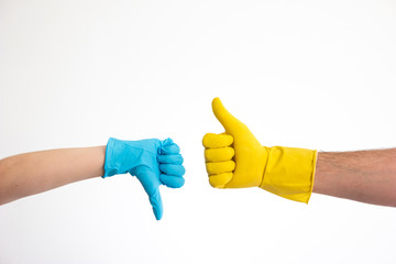 Caucasian woman and man hand in blue and yellow latex gloves doing the thumb up and down signs isolate on white