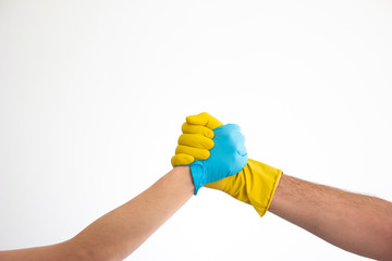 Caucasian woman and man hands and arms in blue and yellow latex gloves shacking hands isolate on white