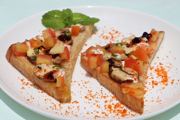 Brushetta or tapas with savory mushroom topping on white plate. Italian antipasti appetizer open toast sandwich