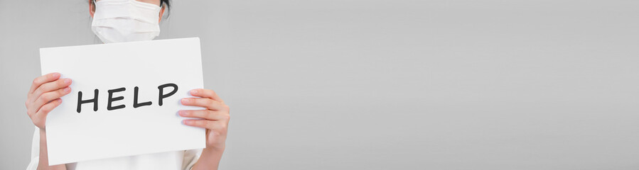 Person with a board with help written on it.  ヘルプと書かれたボードを持つ人