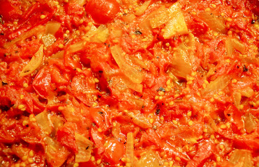 Preparación de salsa de tomate cherry. Salsa recién hecha reposando en la sartén. Tomate, cebolla y orégano fritos en aceite de oliva. Cocina española. Cocina mediterránea.