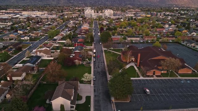 Flying over neighborhood street and slowly rolling up to view mountains from Orem city in Utah.