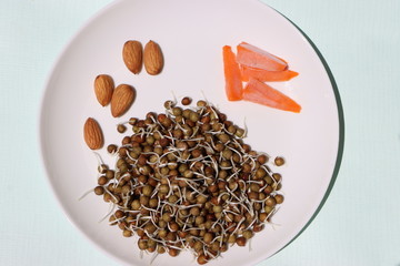 healthy summer salad with black pea sprouts, carrots and dry fruits, macrobiotic food