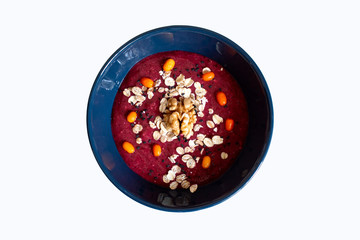 Red berry smoothie sowl with oatmeal, sea-buckthorn, black sesame and walnut isolated on white background