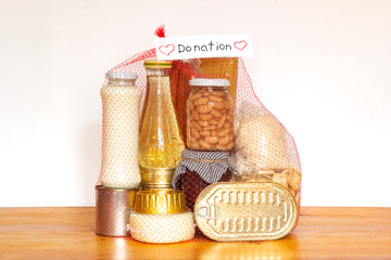 Set of grocery food for needy in crisis, pasta, beans, canned food, and others in red net ready for...