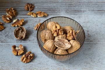 whole walnuts bowl on grey wooden background