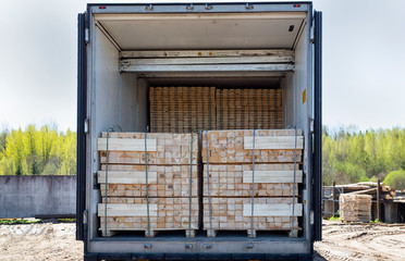 Wooden boards are loaded into a closed truck