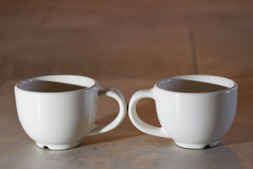deux tasses à café en sens opposé, expresso blanches symboles de séparation, rupture, divorce