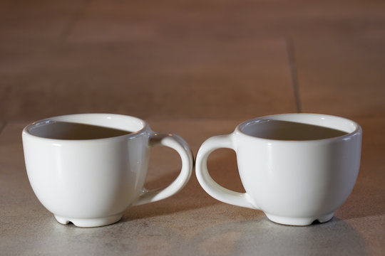 deux tasses &agrave; caf&eacute; en sens oppos&eacute;, expresso blanches symboles de s&eacute;paration, rupture, divorce
