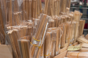 Packets of bamboo wooden knitting needles arranged in rows on a market stall