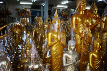 Fototapeta na wymiar various religious gold and bronze figurines in a souvenir shop